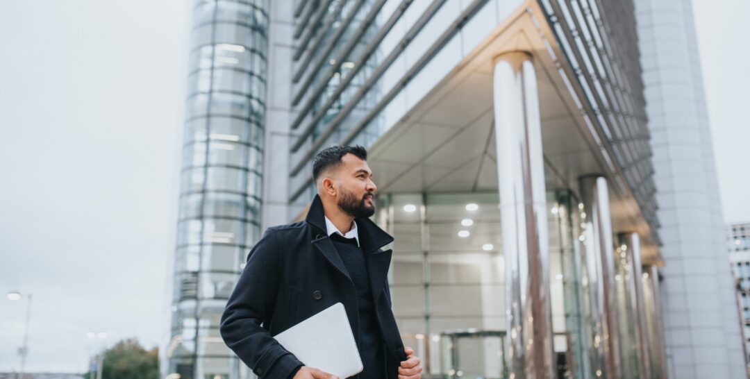 Man in front of large building